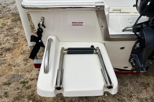 Slide: The Image of 2024 Key West 1720 Center Console boat with foldable swim ladder and stainless steel railing. - 2