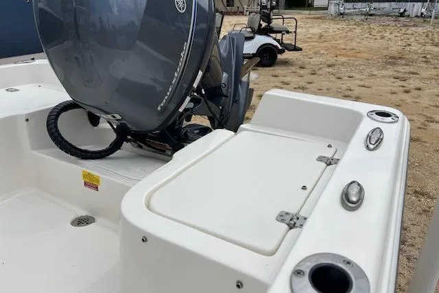 Slide: The Image of 2024 Key West 1720 Center Console boat with outboard motor, docked on sandy terrain. - 3