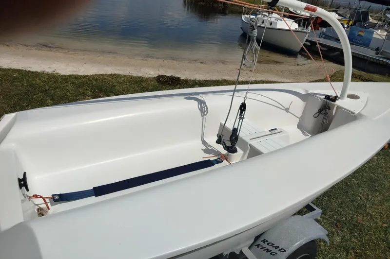 Slide: The Image of 2014 Catalina 12.5 Expo sailboat on trailer by a lakeside. - 12