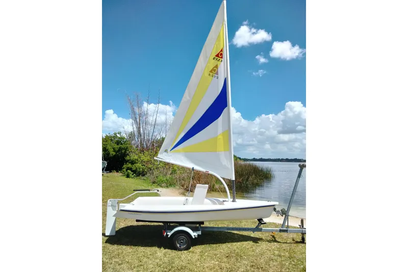 Slide: The Image of 2014 Catalina 12.5 Expo sailboat on trailer by a lake under a blue sky. - 13