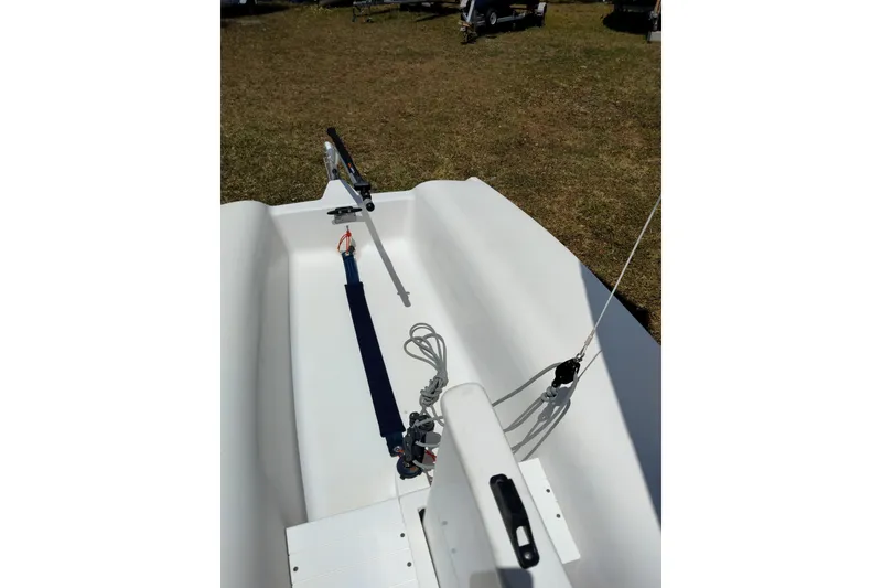 Slide: The Image of 2014 Catalina 12.5 Expo sailboat interior with rigging details on grass. - 2