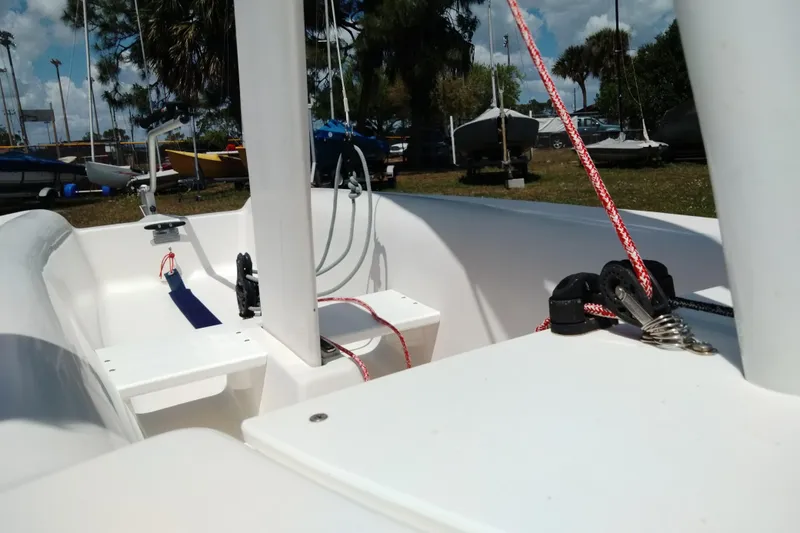 Slide: The Image of 2014 Catalina 12.5 Expo sailboat interior with rigging and ropes, docked outdoors. - 3