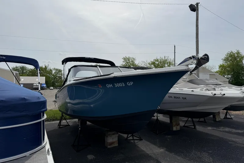 The Image of 2024 Sea Pro 240 Dual Console boat displayed outdoors on stands. - 0