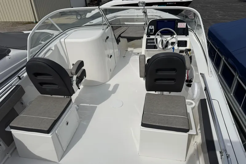 Slide: The Image of 2024 Sea Pro 240 Dual Console boat interior with seating and steering wheel. - 17