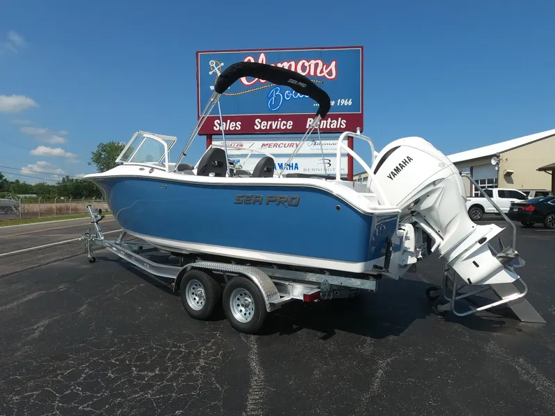 Slide: The Image of 2024 Sea Pro 240 Dual Console boat with Yamaha engine, covered and parked outdoors. - 2