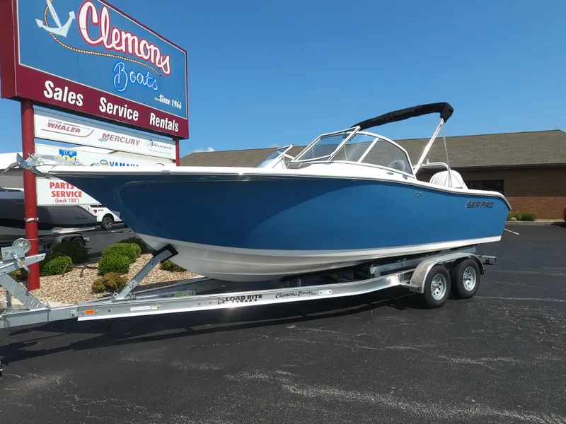 Slide: The Image of 2024 Sea Pro 240 Dual Console boat in blue, displayed outdoors on stands. - 3