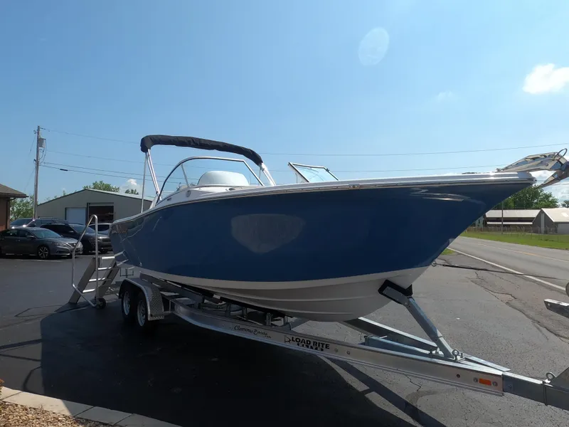 Slide: The Image of 2024 Sea Pro 240 Dual Console boat in storage, blue hull, parked outdoors. - 4