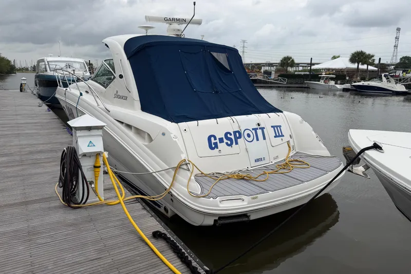 Slide: The Image of 2008 Sea Ray 380 Sundancer docked at marina, featuring blue cover and power connections. - 1