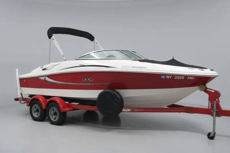 The Image of 2008 Sea Ray 195 Sport boat on red trailer, white and red design. - 0