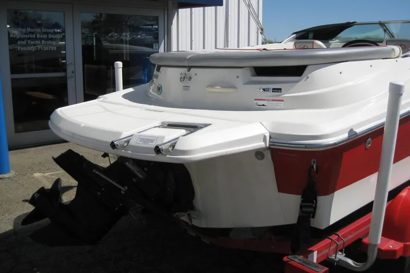 Slide: The Image of 2008 Sea Ray 195 Sport boat, red and white, displayed outside a marine dealership. - 6