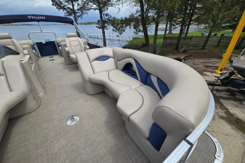 Slide: The Image of 2016 Sylvan Mirage Cruise 8522 LZ pontoon boat with plush seating by a lakeside. - 13