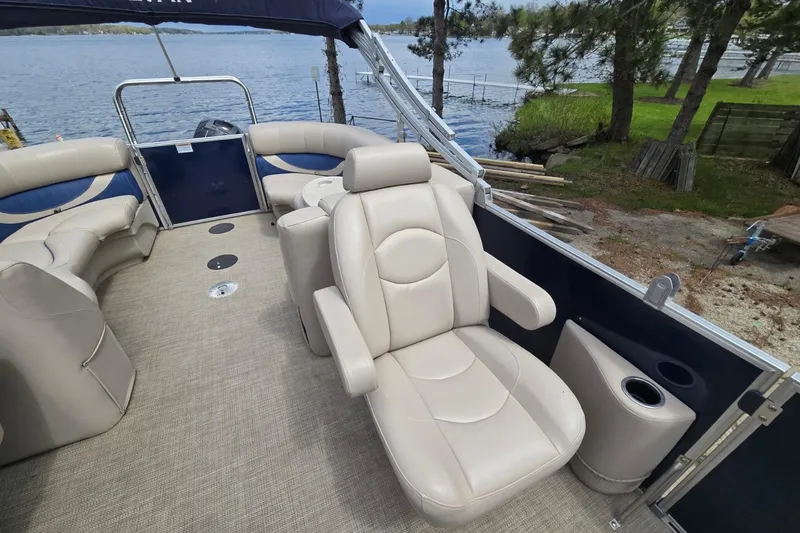 Slide: The Image of 2016 Sylvan Mirage Cruise 8522 LZ pontoon boat with beige seating, docked by a lake. - 16
