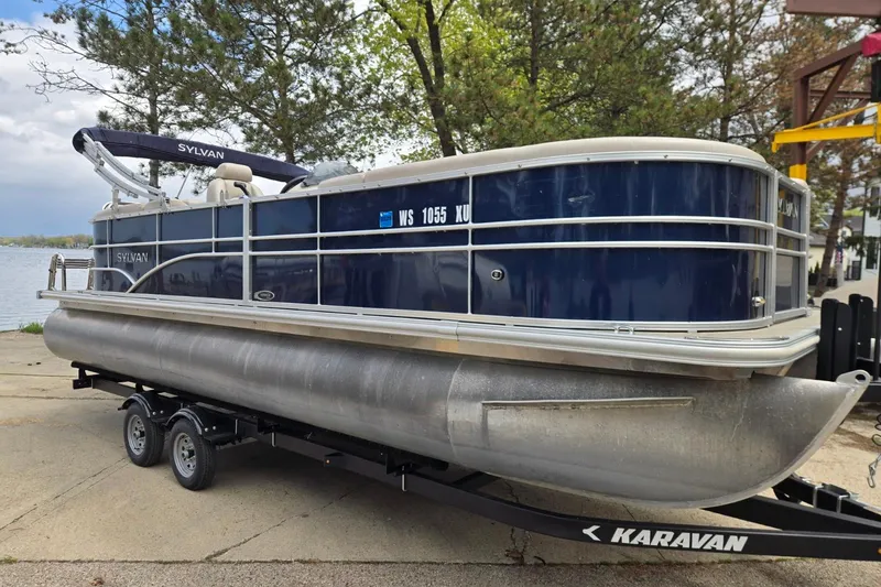 Slide: The Image of 2016 Sylvan Mirage Cruise 8522 LZ pontoon boat on Karavan trailer by a lake. - 2