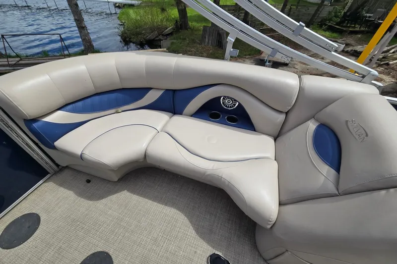 Slide: The Image of Luxurious seating on a 2016 Sylvan Mirage Cruise 8522 LZ pontoon boat, featuring beige and blue upholstery. - 20