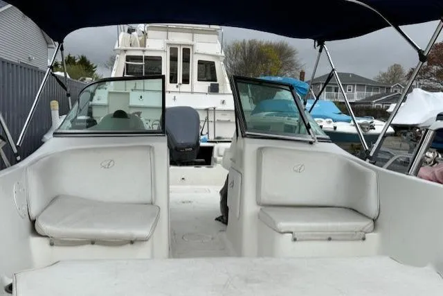 Slide: The Image of 2001 Sailfish 198 DC boat interior with seating and canopy, docked near other boats. - 3