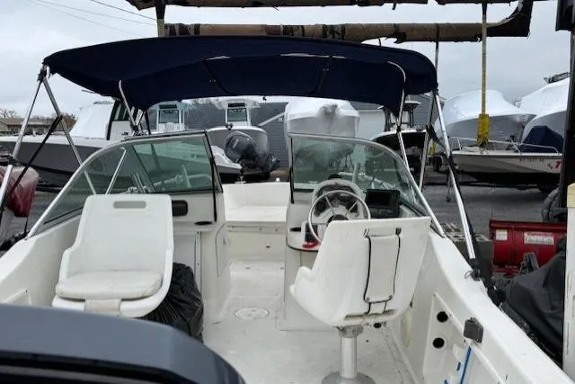 Slide: The Image of 2001 Sailfish 198 DC boat interior with seating and steering wheel, docked outdoors. - 5