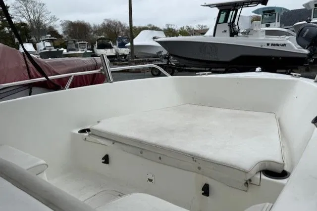 Slide: The Image of 2001 Sailfish 198 DC boat interior with cushioned seating, parked in a marina. - 7