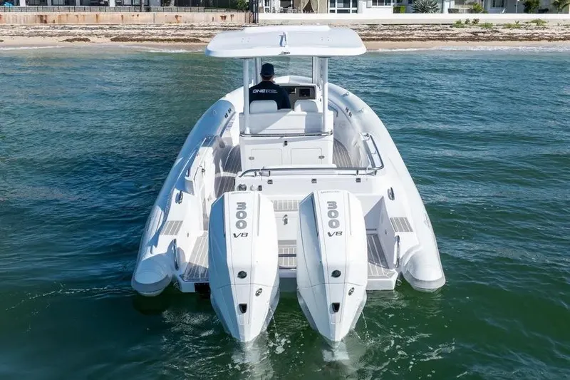 Slide: The Image of Modern Airship 340 boat with dual 300 V8 engines cruising near the shore, 2025 model. - 3