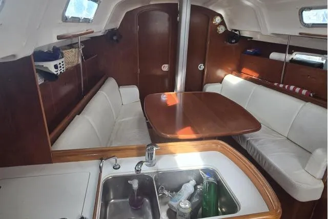 Slide: The Image of Interior of 2002 Beneteau First 36.7 sailboat with wood finish and white seating. - 10