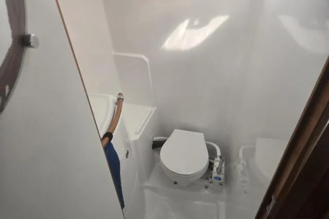Slide: The Image of Compact bathroom in a 2002 Beneteau First 36.7 sailboat, featuring a marine toilet. - 13