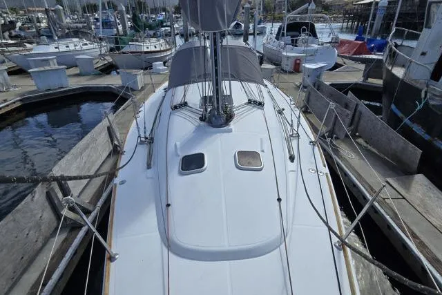 Slide: The Image of 2002 Beneteau First 36.7 sailboat docked at a marina, showcasing its sleek deck design. - 7