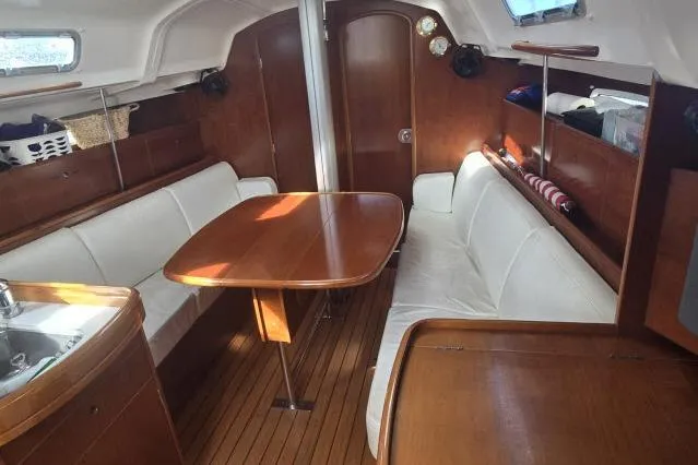 Slide: The Image of Interior of 2002 Beneteau First 36.7 sailboat with wooden furnishings and white seating. - 8