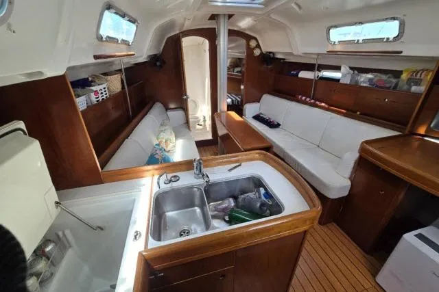 Slide: The Image of Interior of 2002 Beneteau First 36.7 sailboat with wood finish and cozy seating. - 9