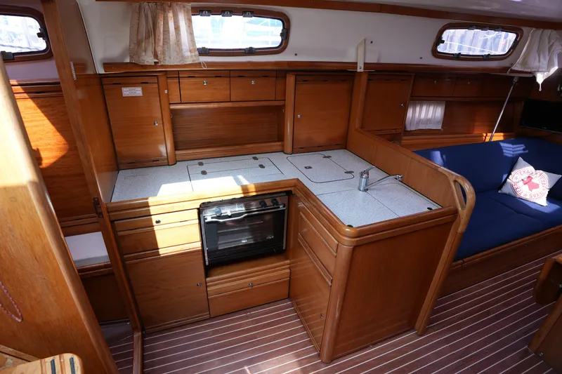 Slide: The Image of Interior of 2007 Bavaria 37 C yacht with wooden cabinetry and compact kitchen area. - 24