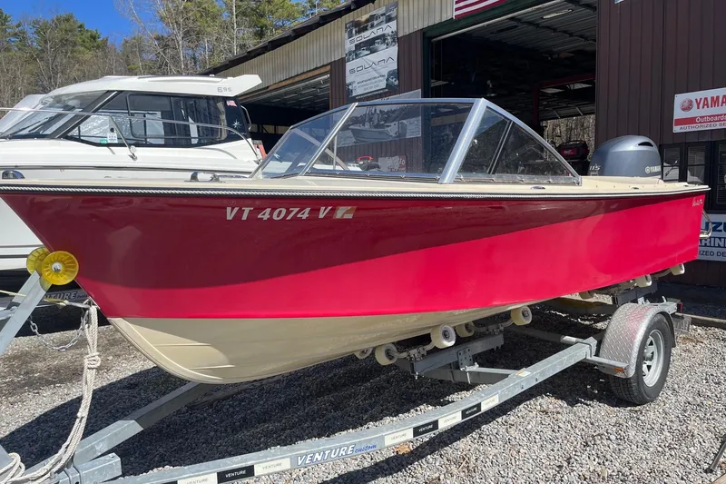 The Image of 2018 Rossiter 17 Closed Deck boat in red, on a trailer, parked outdoors. - 0