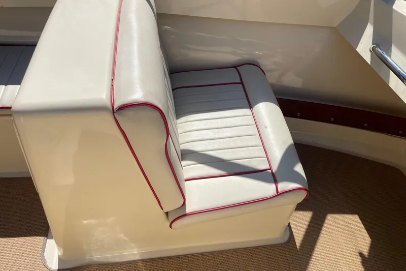 Slide: The Image of 2018 Rossiter 17 Closed Deck boat seat with white upholstery and red trim. - 11