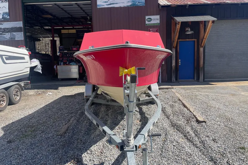 Slide: The Image of Red 2018 Rossiter 17 Closed Deck boat on trailer outside a garage. - 4