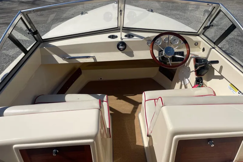 Slide: The Image of 2018 Rossiter 17 Closed Deck boat interior with steering wheel and seating. - 7
