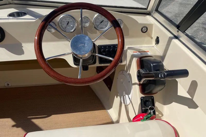 Slide: The Image of Steering wheel and controls of a 2018 Rossiter 17 Closed Deck boat. - 8