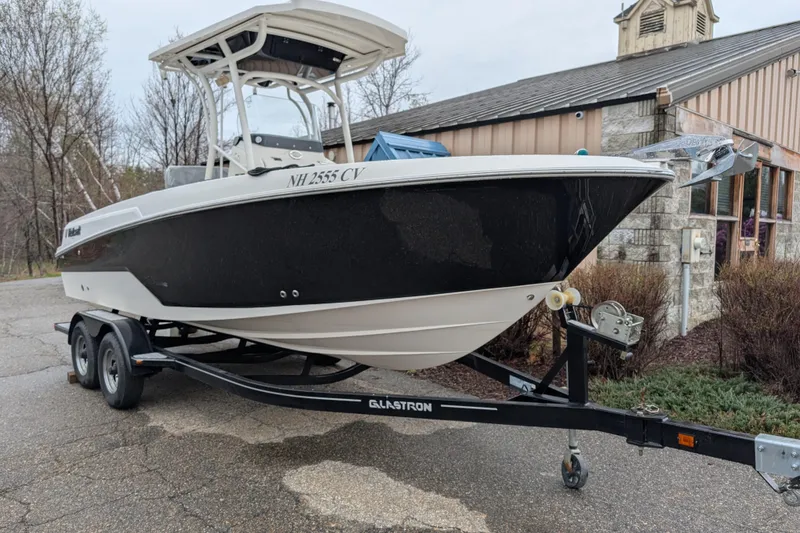 The Image of 2019 Wellcraft 222 Fisherman boat on trailer, parked outdoors near a building. - 0