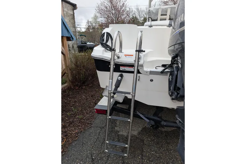 Slide: The Image of 2019 Wellcraft 222 Fisherman boat with ladder and Yamaha motor, parked outdoors. - 16