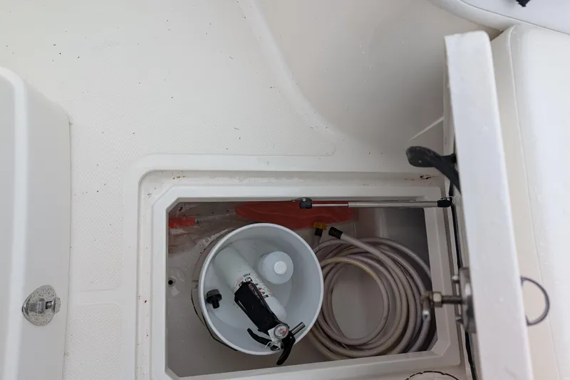 Slide: The Image of Storage compartment of 2019 Wellcraft 222 Fisherman boat with hose and bucket. - 4