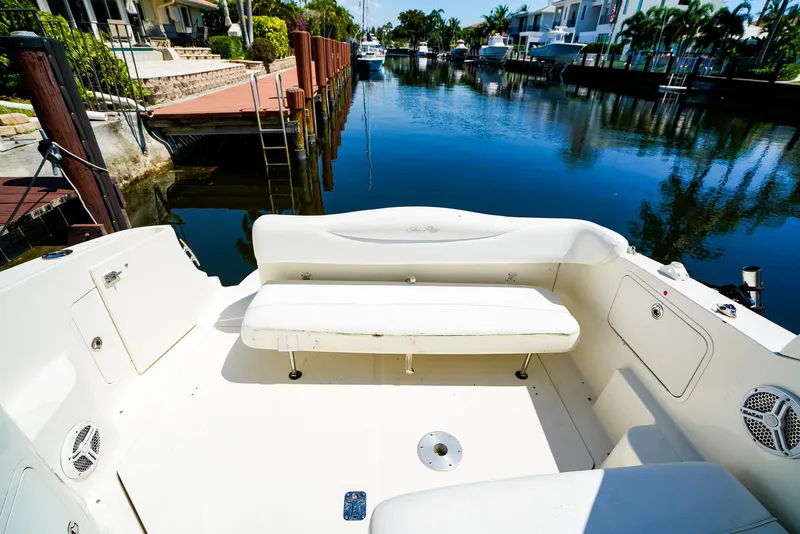 Slide: The Image of 2007 Sea Ray 280 Sundancer boat interior with white seating, docked by a serene canal. - 10