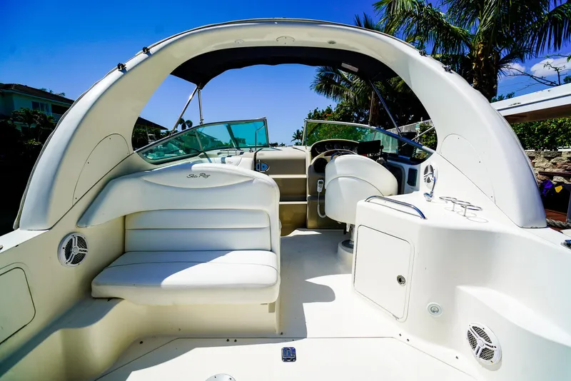 Slide: The Image of 2007 Sea Ray 280 Sundancer boat interior with seating and helm, under clear blue sky. - 12