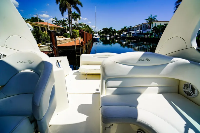 Slide: The Image of 2007 Sea Ray 280 Sundancer boat interior with white seating, docked in a scenic canal. - 18