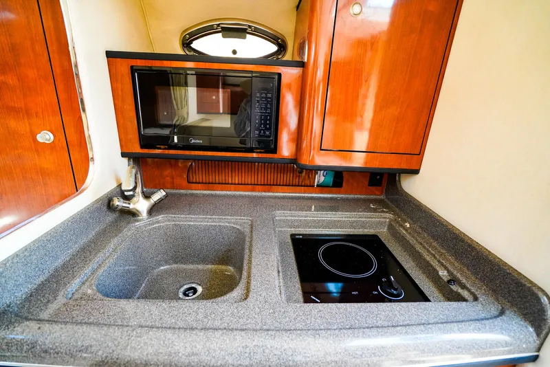 Slide: The Image of 2007 Sea Ray 280 Sundancer galley with sink, stove, and microwave. - 21