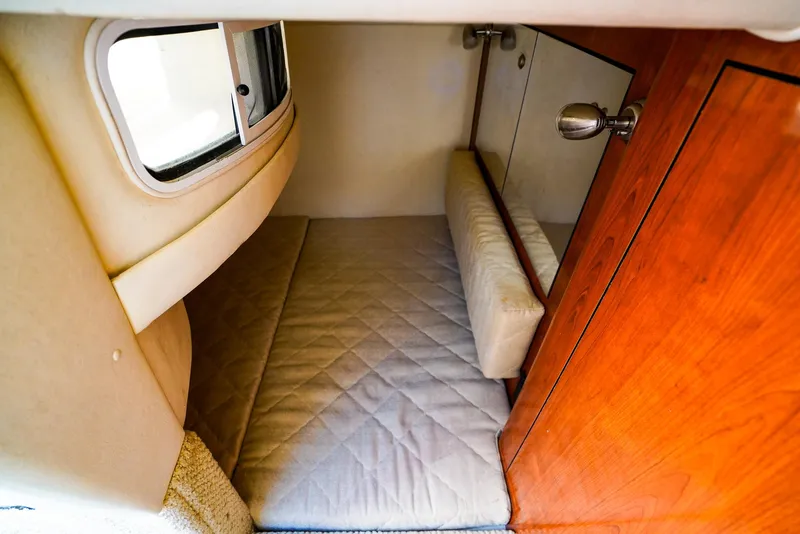 Slide: The Image of 2007 Sea Ray 280 Sundancer cabin interior with bed and wooden door. - 26