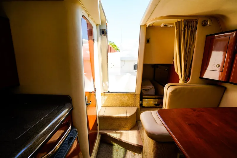 Slide: The Image of Interior of 2007 Sea Ray 280 Sundancer, featuring cozy seating and wooden cabinetry. - 28