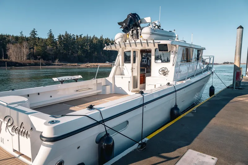 Slide: The Image of 2019 Lindell 46' boat docked by a scenic waterfront with trees. - 2