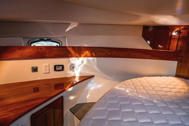 Slide: The Image of Luxurious cabin interior of 2019 Lindell 46' yacht with wood accents and quilted bedding. - 21