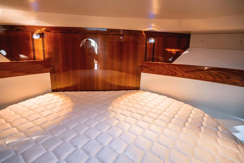 Slide: The Image of Luxurious cabin interior of 2019 Lindell 46' yacht with plush bedding and wooden accents. - 29