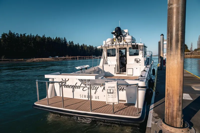 Slide: The Image of 2019 Lindell 46' boat docked in serene waters, surrounded by lush forest. - 4