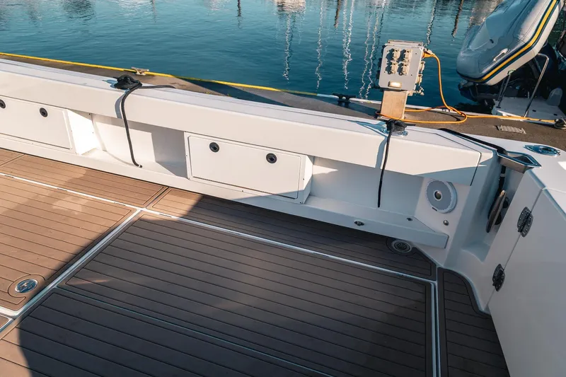 Slide: The Image of Spacious deck of 2019 Lindell 46' boat with wood finish and dockside view. - 47