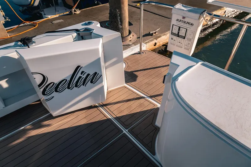 Slide: The Image of Deck of 2019 Lindell 46' boat with "Reelin" logo, docked near water. - 48