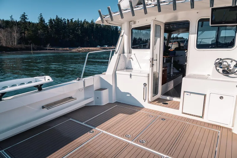 Slide: The Image of Spacious deck of a 2019 Lindell 46' boat with open cabin door. - 52