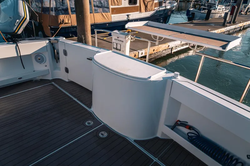 Slide: The Image of 2019 Lindell 46' yacht deck with teak flooring and marina view. - 57